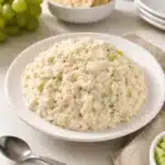 Bowl of Classic Carol Chicken Salad garnished with herbs.